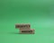 Urgently needed symbol. Concept word Urgently needed on wooden blocks. Beautiful green background. Business and Urgently needed