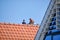 Urk, The Netherlands - June 15, 2020 Two men drink coffee on the roof. Construction, roofer or carpenter. Roof installation work.