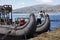 Uros, Peru Traditional Totora boat with tourists on Titicaca lake near to the Uros floating islands , Puno, Peru,
