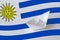 Uruguay flag depicted on paper origami ship closeup. Handmade arts concept
