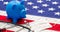 US of America health budget. Medical stethoscope, protective mask and piggy bank on a USA flag, closeup view