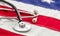 US of America health. Medical stethoscope on a USA flag, closeup view