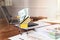 US dollar banknote and credit card in mini shopping cart and office equipment on office desk. Interior of vintage retro office