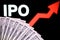 US dollar bills and IPO letters with red arrow on the blurred background. Concept for initial public offering