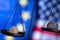 US Dollar coin and EU currencies on weighing scale against Unated States and European Union flags as symbol of  trade war,