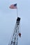 US Flag flies in breeze atop a crane