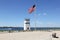 US flag flying on a pole and abandoned watch tower on the beach at Breezy Point, Queens, NY, USA