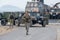 US Marine in jungle camouflage uniform walks on the road to lead a humvee to the parking area