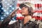USA celebration. Portrait of a female soldier saluting, against the background of the American flag. Side view. Multi-exposure