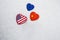 USA, China, EU national flags on heart shaped boxes laying on snow close together. Concept of economic political relationships.