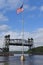 USA flag in front of a lift bridge