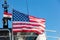 USA flag on pole on ferry`s stern. Ongoing cruise to islands. Blue sky background