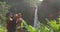 USA Hawaii couple tourists taking travel selfie with phone by Hawaii waterfall