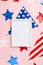 USA Independence Day concept. Top view vertical photo of photo frame over national flag garland and stars on isolated pastel pink
