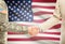 USA military man in uniform and civil man in suit shaking hands with national flag on background - United States