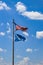 USA and Oklahoma flags flying against a very blue sky with fluffy white clouds on a windy day