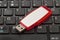 USB memory stick - Red flash drive on top of a dark computer keyboard