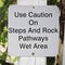 A use caution on steps and rock pathways sign
