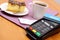 Use payment terminal for paying for cheesecake and coffee in cafe, finance concept