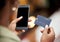 Use your phone to simplify your life. a young woman using her smartphone to make card payments.