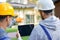 Use your vision. Close up of two young male builders using digital tablet pc, discussing ideas while working at cottage