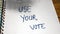 Use your vote, handwriting  text on paper, political message. Political text on office agenda. Concept of democracy, voting,