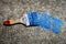 Used blue paint brush on concrete surface. There is a blue trace of paint from the brush. Unwashed wooden brush for painting the