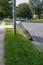 Used box spring mattress leaning against a utility pole left on the side of a street waiting for trash pickup