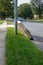 Used box spring mattress leaning against a utility pole left on the side of a street waiting for trash pickup