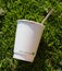 Used coffee cup and stir stick on the ground. Paper cup recyclable