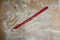 Used construction or industrial wooden red graphite pencil on wooden desk with sawdust
