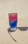 Used cosmetic sunscreen tube and sunglasses shadow on sandy beach