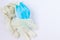 Used, infected with the virus, covid individual white disposable gloves and a medical blue mask are thrown away unnecessary. Ecolo