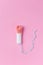 Used medical female tampon over a pink background. Menstruation, means of protection