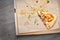 Used opened pizza box with slice of pizza, stains and crumbs inside on wooden table background