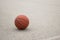 Used orange leather basketball on grey asphalt background.