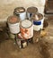 Used Paint Cans Stacked on Basement Floor