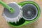 Used round spin mop with microfiber head, green handle on cleaning bucket