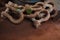 Used and rusty stained lifting shackles lying on a floor in a dirty container with lashing and lifting equipment onboard of a ship