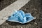 Used surgical mask thrown on the asphalt