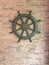 Used to rudder the old wooden boat on the background of red brick cement wall.steering wheel vintage wooden with a sea ship