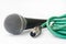 Used vocal microphone with old green xlr cable on the white back