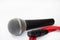 Used vocal microphone with red xlr cable on the white background