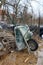 Used wheelbarrow construction cart leaning against wire fence