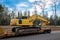 Used Yellow Skid Steer Excavator Loader on a flat bed trailer