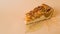 Useful baking.  An appetizing piece of apple pie with pecans on autumn leaves on a plain light brown background