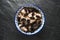 Useful barley porridge with raisins in a bowl on a gray stone