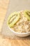 Useful breakfast. Oatmeal with kiwi. Neutral background