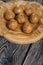 Useful homemade sweets.  Coconut flour with dark chocolate.  In the form of balls.  On pine boards