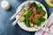 Useful tasty salad of spinach, chard, avocado and grapefruit with olive oil on an old concrete dark background. Selective focus.